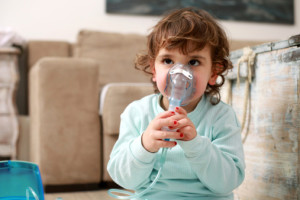 Portrait of a little girl with inhaling mask