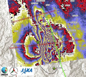 Figura 2 Interferogramma ALOS 2. L'ellissi mostra la zona in cui il terreno si è allontanato dal satellite lungo la linea di vista. Questa direzione è inclinata rispetto alla verticale di 34° verso est. Le linee che tagliano l'interferogramma da ovest a est sono le tracce dei profili in figura 3.